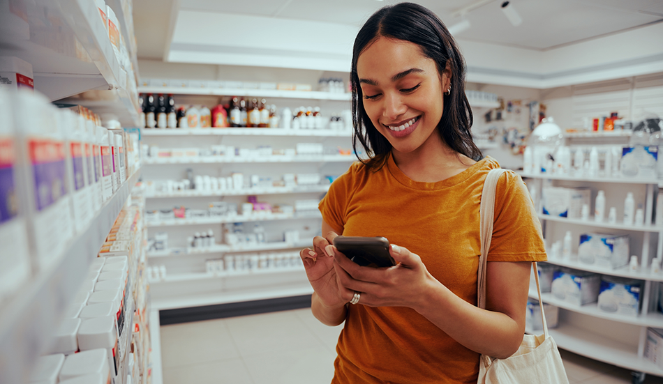 Woman using mobile phone in pharmacy